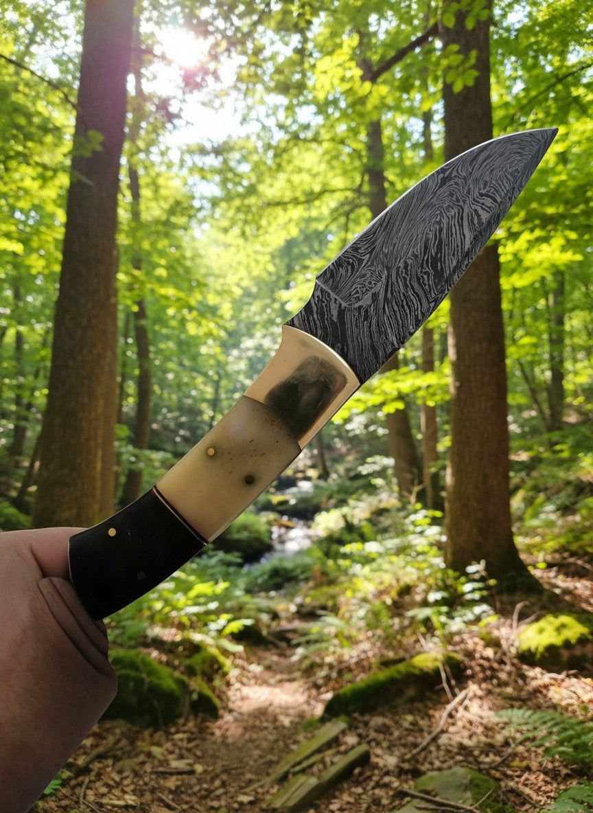 SUSA KNIVES 8-inch handmade damascus steel skinner knife with a two-tone bone and dark wood handle in a forest setting.