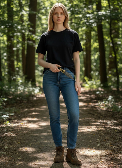 Woman in a forest holding a SUSA KNIVES handmade damascus steel skinner knife with a patterned blade